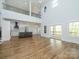Bright, open living area with hardwood floors, loft area, modern lighting, and a view of the kitchen at 2008 Plain Field Dr, Bessemer City, NC 28016