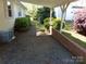 Gravel driveway with brick retaining wall and lush greenery, offering a private outdoor space at 202 S Love Chapel Rd, Stanfield, NC 28163