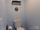 Cozy bathroom showcasing a toilet, mounted shelves and a fun sign at 202 S Love Chapel Rd, Stanfield, NC 28163
