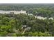 Stunning aerial view of a lakeside home with a swimming pool nestled among lush green trees and serene waters at 208 Grasshopper Cir, Mooresville, NC 28117