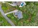 Aerial view of a home with mature landscaping, in-ground pool, lush green lawn and long driveway at 208 Grasshopper Cir, Mooresville, NC 28117