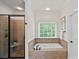 Bathroom featuring separate shower and soaking tub beneath a window at 208 Grasshopper Cir, Mooresville, NC 28117