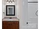 Well-lit bathroom features a vanity with granite countertop, undermount sink, framed mirror and shower at 208 Grasshopper Cir, Mooresville, NC 28117