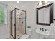 Bathroom features glass shower, decorative tile, toilet, pedestal sink, and window at 208 Grasshopper Cir, Mooresville, NC 28117