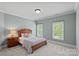 Cozy bedroom featuring neutral walls, carpet, wooden furniture, and bright windows at 208 Grasshopper Cir, Mooresville, NC 28117