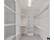 Walk-in closet features custom white shelving and hanging rods, and neutral carpet at 208 Grasshopper Cir, Mooresville, NC 28117
