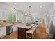 Open kitchen layout with a central island, stainless steel appliances, and hardwood floors overlooking living spaces at 208 Grasshopper Cir, Mooresville, NC 28117