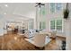 Open-concept living area showcasing soaring ceilings, large windows, hardwood floors, and a seamless flow to the kitchen at 208 Grasshopper Cir, Mooresville, NC 28117
