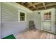 View of covered porch features an outdoor chair and a partial view of the yard at 220 Tomberlin Rd, Mount Holly, NC 28120