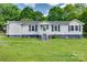 Charming single-story home featuring a well-maintained lawn, dark shutters, and a welcoming front entrance at 220 Tomberlin Rd, Mount Holly, NC 28120
