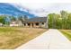 Craftsman-style home with wood columns, green siding, and a long concrete driveway at 2212 University Dr, Lancaster, SC 29720