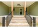 Covered front porch with stained wood columns, brick steps, and black metal railings at 2212 University Dr, Lancaster, SC 29720