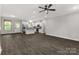 Open-concept living area featuring modern kitchen, dark floors, and a stylish ceiling fan at 2212 University Dr, Lancaster, SC 29720