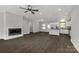 Spacious living room with dark floors, fireplace, modern kitchen, and ample natural light at 2212 University Dr, Lancaster, SC 29720