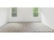 Bright, carpeted bedroom with natural light from two large windows at 24558 Blue Heron Cir # 402, Lancaster, SC 29720
