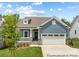 Attractive blue house with a two-car garage, a cozy front porch, and well-maintained landscaping at 24558 Blue Heron Cir # 402, Lancaster, SC 29720