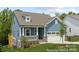 Inviting blue home with a covered porch, stone accents, and a two-car garage showcases attractive curb appeal at 24558 Blue Heron Cir # 402, Lancaster, SC 29720