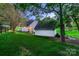 Lush green backyard with mature trees, a deck, and a detached garage for a private outdoor experience at 308 Valhalla Dr, Harrisburg, NC 28075