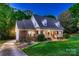 Well-maintained brick house with a welcoming front porch, dormers, and landscaped garden at 308 Valhalla Dr, Harrisburg, NC 28075
