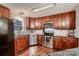 Modern kitchen with stainless steel appliances, dark wood cabinets, and granite countertops at 308 Valhalla Dr, Harrisburg, NC 28075