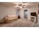 Inviting living room featuring a comfortable sofa, ceiling fan, and neutral decor for a relaxing ambiance at 308 Valhalla Dr, Harrisburg, NC 28075