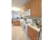 Practical kitchen featuring white appliances, wood cabinets, and tile flooring at 317 Robert Keever Rd, Stanley, NC 28164