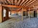 Spacious unfinished basement with exposed ceiling, gravel flooring, and a doorway at 3308 Watkins Rd, Monroe, NC 28110