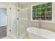Primary bathroom features free-standing tub, glass shower and large window at 3308 Watkins Rd, Monroe, NC 28110