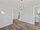 Bright dining area featuring hardwood floors, a modern chandelier, and a view into the kitchen at 3308 Watkins Rd, Monroe, NC 28110