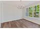 Bright dining area featuring hardwood floors, a modern chandelier, and large windows offering picturesque views at 3308 Watkins Rd, Monroe, NC 28110