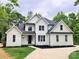 Beautiful two-story home with white siding, black accents, a well manicured lawn, and a concrete driveway at 3308 Watkins Rd, Monroe, NC 28110