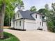 View of the side exterior elevation with a white garage door and white siding against a well manicured lawn at 3308 Watkins Rd, Monroe, NC 28110