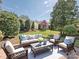 Outdoor patio in a lush back yard features outdoor seating and mature landscaping at 43014 Mimosa Ct, Indian Land, SC 29707