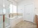 Well-lit bathroom with a soaking tub, shower, and tiled floors, offering a spa-like experience at 43014 Mimosa Ct, Indian Land, SC 29707