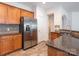 Kitchen features stainless steel refrigerator, granite countertops, and wooden cabinets at 43014 Mimosa Ct, Indian Land, SC 29707