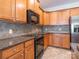 Kitchen area features wooden cabinets, stone countertops, updated appliances and tiled backsplash at 43014 Mimosa Ct, Indian Land, SC 29707
