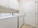 The laundry room features a washer, dryer, white cabinets, and a door to outside at 43014 Mimosa Ct, Indian Land, SC 29707