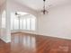 Spacious living area with hardwood floors, chandelier, and an open archway to another room at 43014 Mimosa Ct, Indian Land, SC 29707