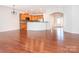 Open-concept living area with hardwood floors flowing into a kitchen with breakfast bar at 43014 Mimosa Ct, Indian Land, SC 29707
