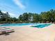 A large, outdoor swimming pool with lap lanes, lounge chairs, and trees in a neighborhood at 43014 Mimosa Ct, Indian Land, SC 29707