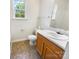 Bathroom features a wooden vanity with a sink and a window for natural light at 4437 Devonhill Ln, Charlotte, NC 28269
