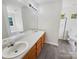 Well-lit bathroom with double sink vanity, large mirror, and tiled floor at 4437 Devonhill Ln, Charlotte, NC 28269