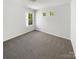 Clean and bright bedroom with a single large window and two smaller windows at 4437 Devonhill Ln, Charlotte, NC 28269