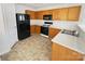 Functional kitchen equipped with black appliances, laminate countertops, and wood cabinets at 4437 Devonhill Ln, Charlotte, NC 28269
