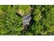 Aerial view of home surrounded by lush green trees and a deck with blue umbrellas at 4516 Stryker Dr, Matthews, NC 28104