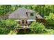 Back exterior showcasing a large deck with outdoor seating surrounded by lush greenery at 4516 Stryker Dr, Matthews, NC 28104