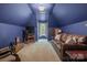 Cozy bedroom featuring blue walls, a large sofa, and a window with natural light at 4516 Stryker Dr, Matthews, NC 28104