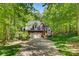 Brick home with a two car garage and a long driveway surrounded by trees and lawn at 4516 Stryker Dr, Matthews, NC 28104