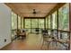 Spacious screened-in porch with ceiling fan, table set and views of the wooded yard at 4516 Stryker Dr, Matthews, NC 28104