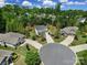 Aerial view of a two-story home in a cul-de-sac with mature trees, manicured landscaping and circular driveways at 5025 Willing Ct, Fort Mill, SC 29707